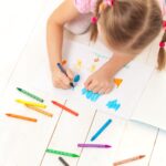 Dziewczynka rysująca obrazek kredkami